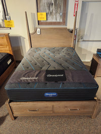 A Beauty-rest Mira TT Medium Mattress is displayed on a storage bed frame in a furniture showroom.
