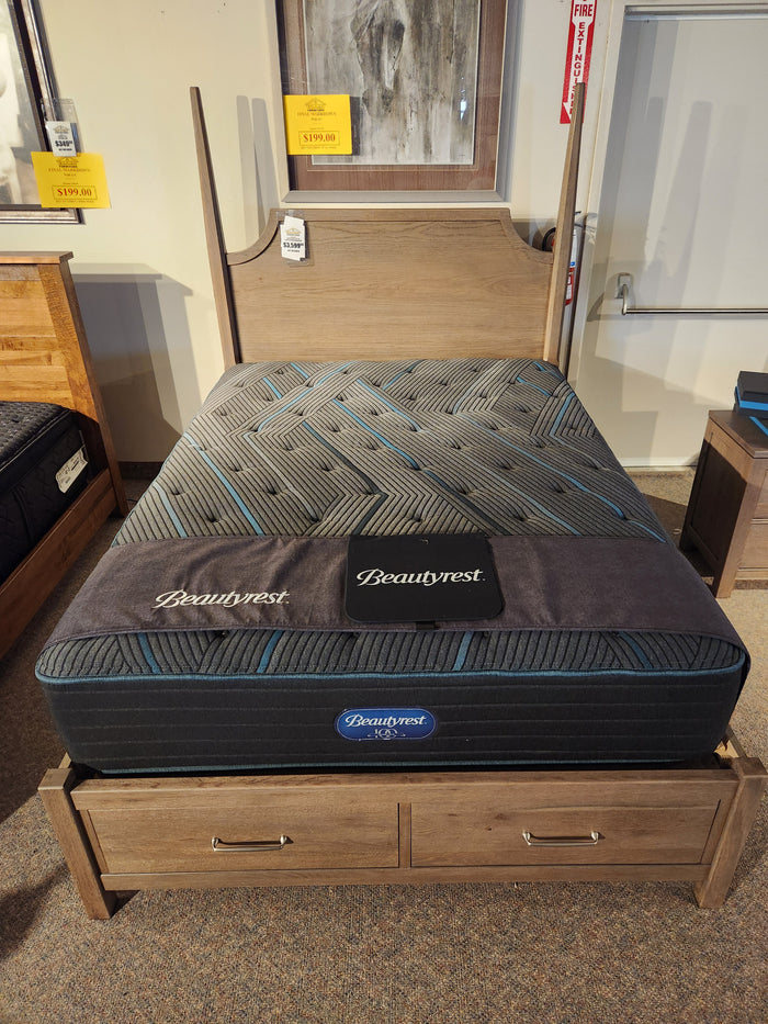 A Beauty-rest Mira TT Medium Mattress is displayed on a storage bed frame in a furniture showroom.