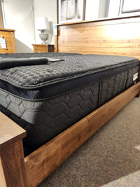 The Beauty-rest Apollo PT Medium Mattress with a pocket coil system is displayed on a wooden bed in the showroom.