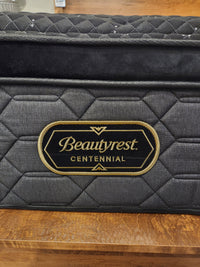 A close-up of a Beauty-rest Adonis PT Plush Mattress with micro coils and a black and gold label on quilted gray fabric.