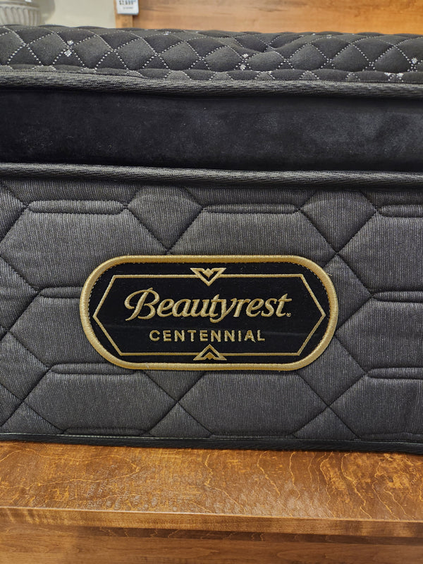 A close-up of a Beauty-rest Adonis PT Plush Mattress with micro coils and a black and gold label on quilted gray fabric.