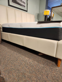 The Palliser 77140 Verttia King Upholstered Bed with customizable cover and mattress is displayed in a furniture store.