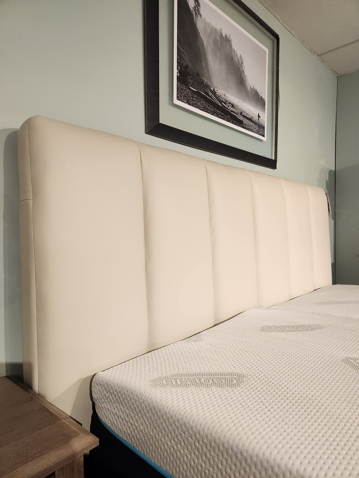The Palliser 77140 Verttia King Upholstered Bed pairs with a mattress and framed landscape, with customizable options.