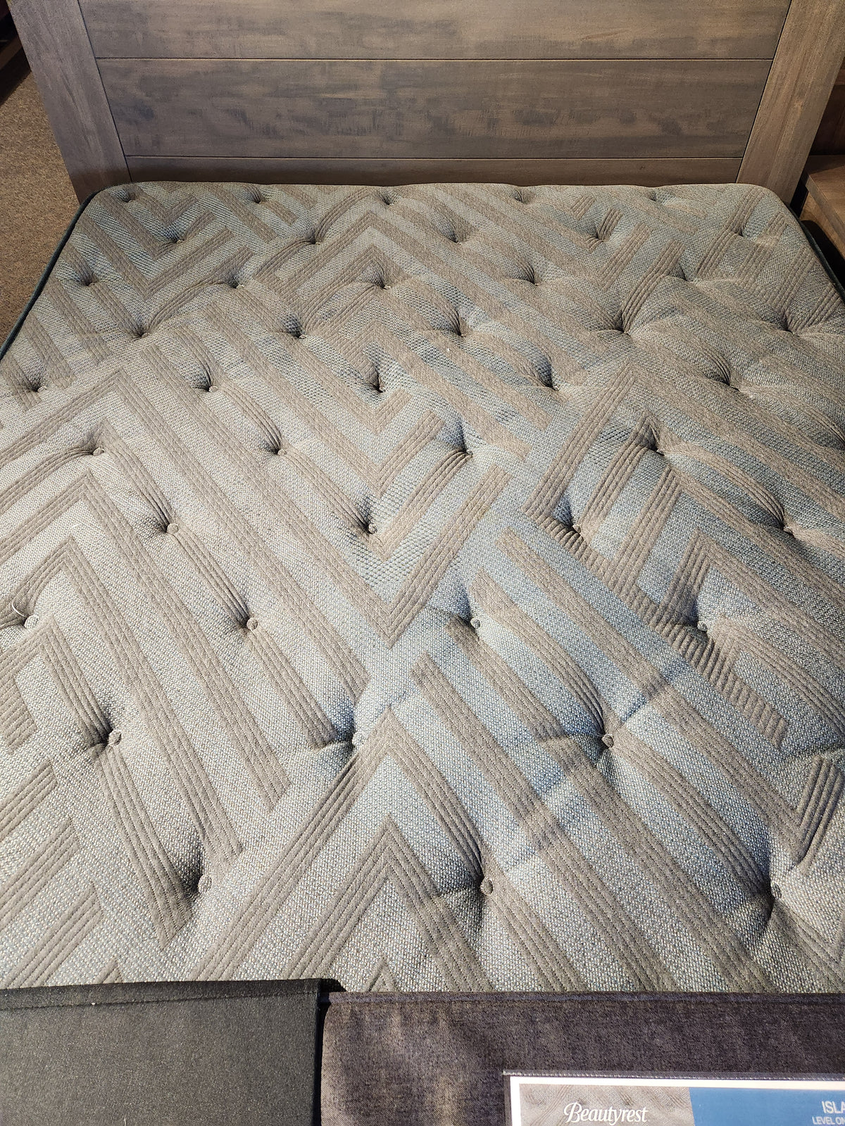 A close-up of the Beauty-rest Isla PT Firm Mattress with pocket coils and geometric, tufted button details.