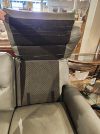A gray recliner chair with its backrest cover lifted, resembling the Leather Craft Texas Power Reclining Loveseat.