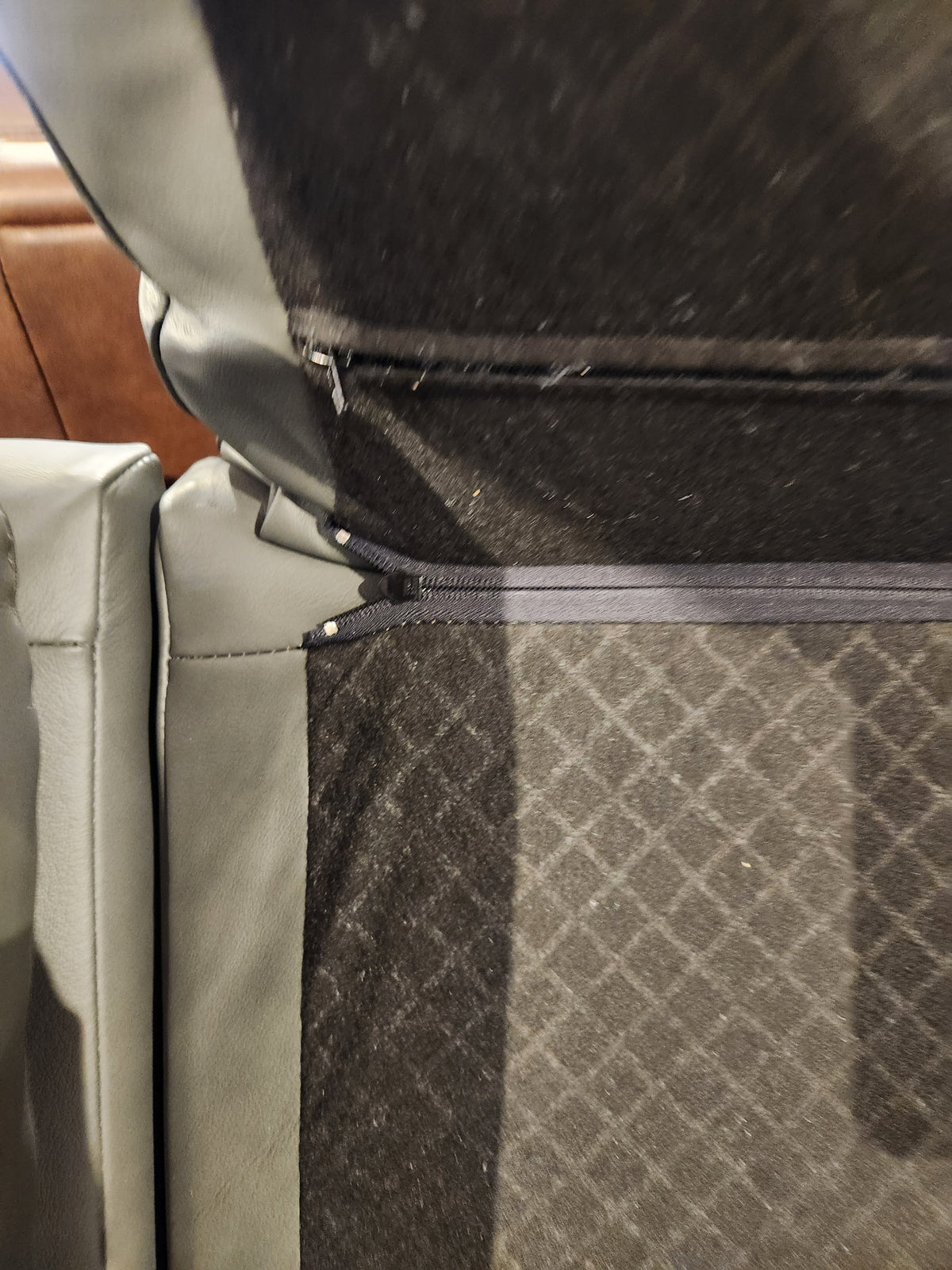 Close-up of the gap between sections of the grey Leather Craft Texas Power Reclining Sofa, showing texture and stitching.