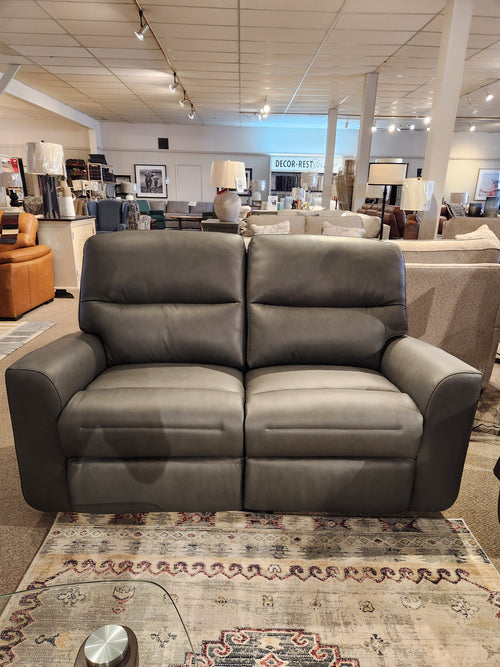Leather Craft Texas Power Reclining Loveseat showcased in a showroom with lamps and matching furniture.