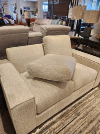 Experience the Leather Craft Mesa Loveseat—a beige upholstered display blending modern elegance and luxurious comfort.