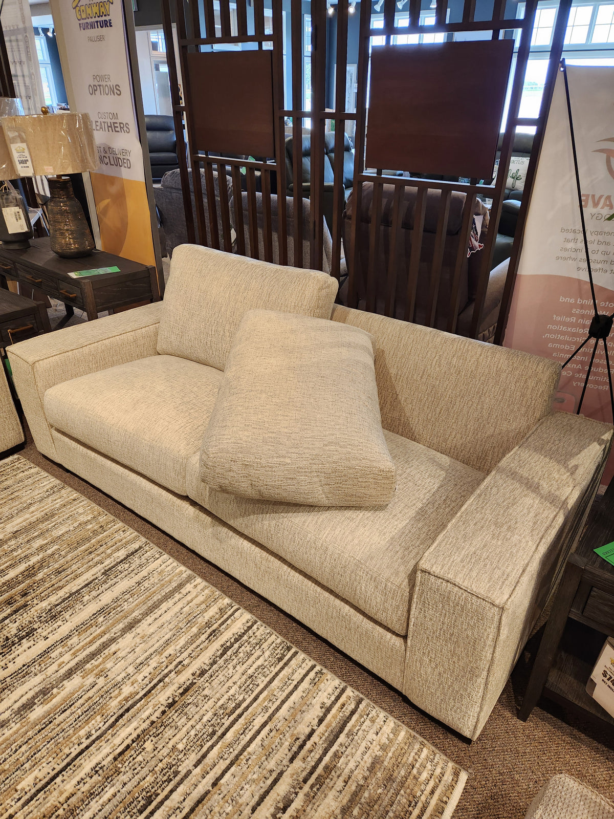 The Leather Craft Mesa Sofa in light beige with two seat cushions adds modern elegance to any furniture showroom.