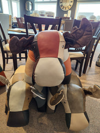 Three Reiner's Originals Moose Leather Animal Ottomans are displayed on a carpeted showroom floor.