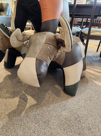 Reiner's Originals Reiner's Leather Animal Ottomans--Moose, a faux leather moose ottoman on a carpeted floor.
