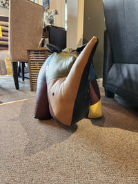 A Reiner's Originals Reiner's Leather Animal Ottomans-- Rhino sits on a carpet between chairs in a living room.