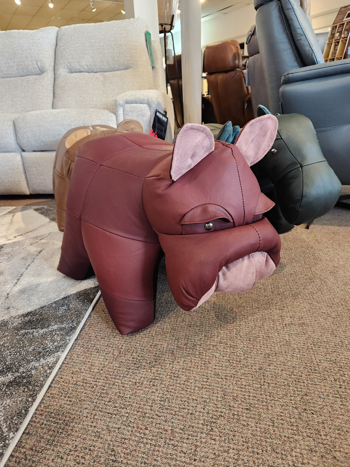Reiner's Originals Reiner's Leather Animal Ottomans--Bulldog is displayed on a carpeted floor in a furniture store.