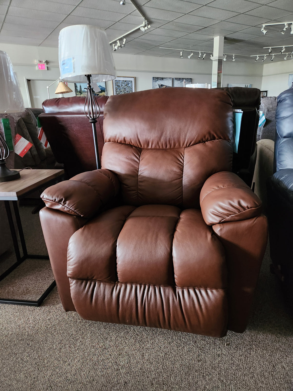 La-Z-Boy 766 Morrison All Leather Rocker Recliner in brown on display for comfort between lamps and other chairs.