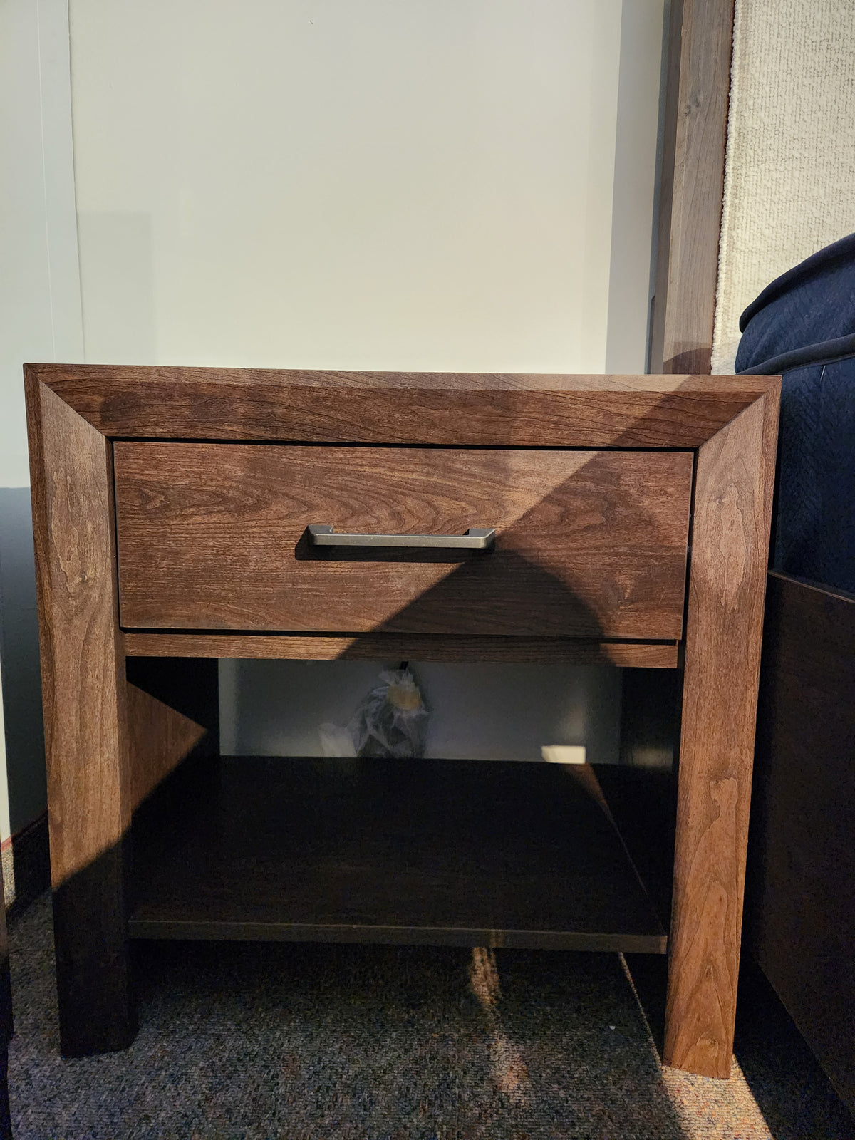 The Magnussen Llewellyn B5907 Night Stand features a walnut finish, drawer, shelf, and built-in USB charger.