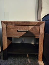 The Magnussen Llewellyn B5907 Night Stand features a walnut finish, drawer, shelf, and built-in USB charger.