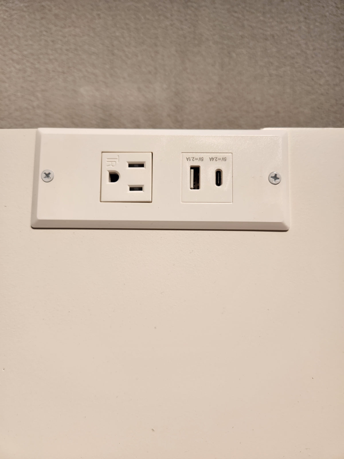 The 834 Laptop Desk by Ben & Erin Napier from Vaughan Bassett pairs well with a white wall plate featuring USB ports.
