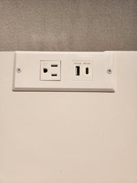 The 834 Laptop Desk by Ben & Erin Napier from Vaughan Bassett pairs well with a white wall plate featuring USB ports.