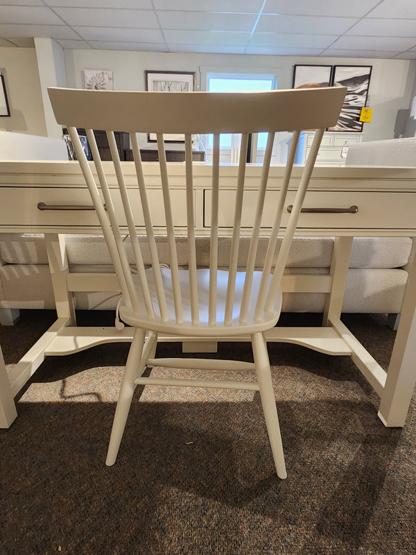 The 834 Laptop Desk Chair by Ben & Erin Napier for Vaughan Bassett sits in front of a matching desk in a showroom.