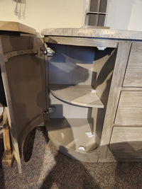 The Magnussen D5874 Braelyn Buffet w/Stone Top features two curved shelves in the corner when the door is open.