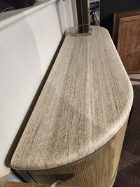 The Magnussen D5874 Braelyn Buffet w/Stone Top features elegant beige granite and a wood base in Mid-Century Modern style.