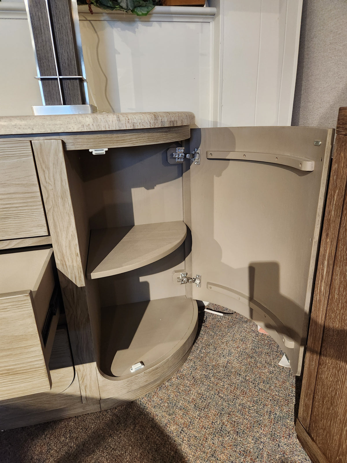 The Magnussen D5874 Braelyn Buffet w/Stone Top features two curved shelves and an open door revealing storage inside.