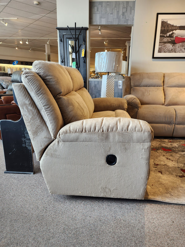 La-z-boy 761 Joel Reclining Loveseat in beige corduroy, with cushioned arm pads, shown among sofas and decor in showroom.