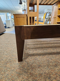 Close-up of the Willa Queen Platform Bedframe leg by Fashion, highlighting its minimalist design on carpet in a showroom.