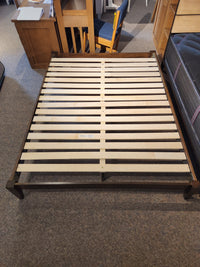 The Fashion Willa Queen Platform Bedframe features a minimalist wooden design with slatted base, displayed in a showroom.