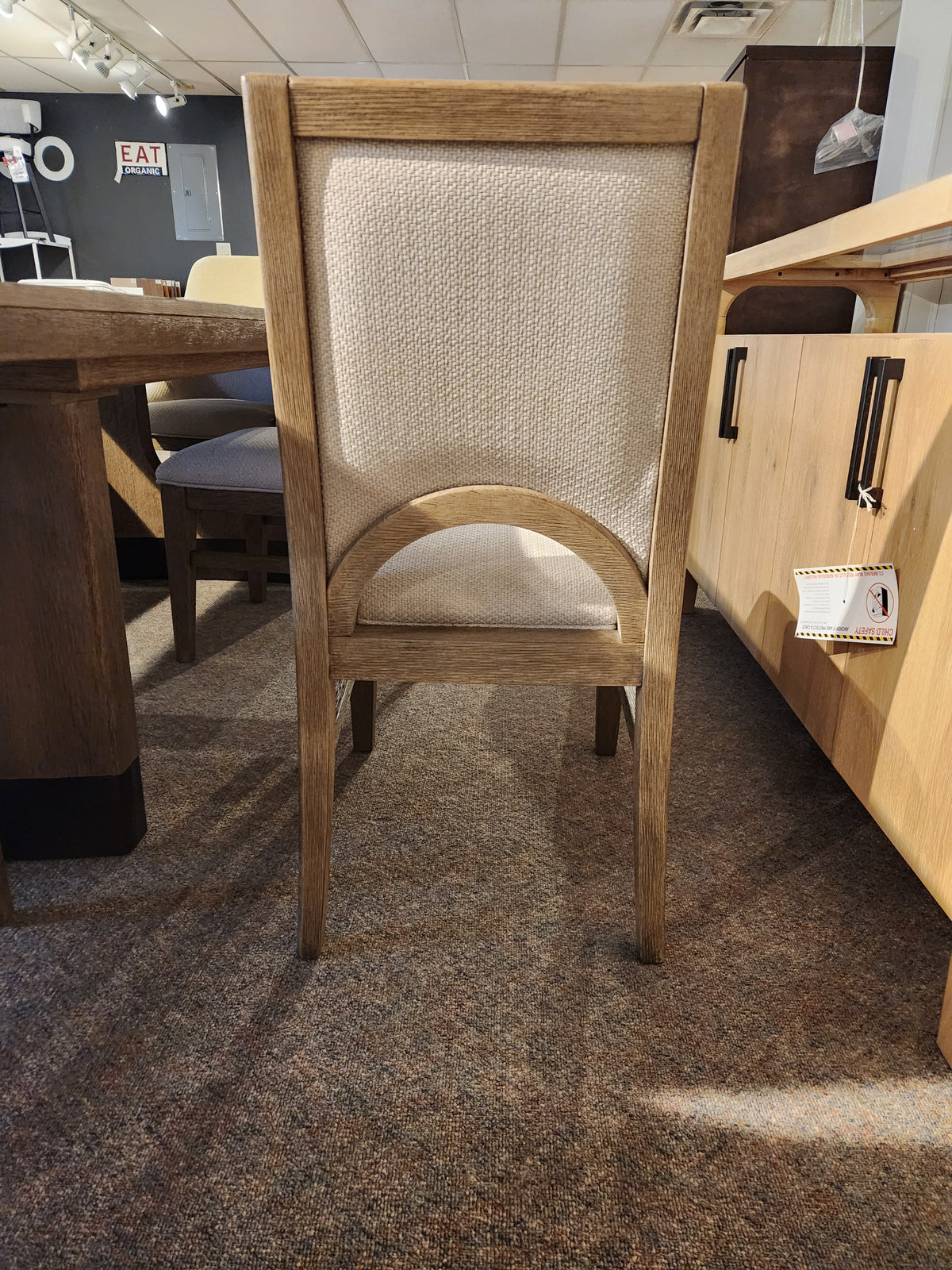 Magnussen D5878 Trestle 5 Piece Dining Package: honey wheat wooden chair with light upholstery shown on carpet.