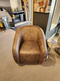 Field & Stream Airily Swivel Chair by Best on a carpeted showroom floor with modern lodge-style furniture in view.