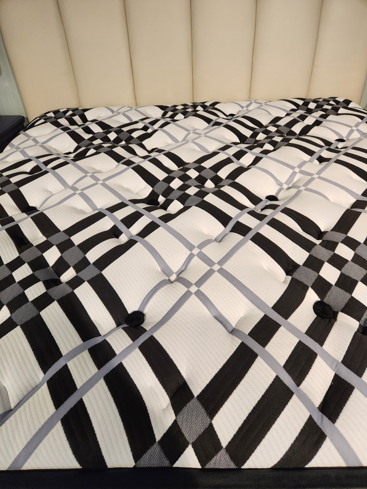 KingsDown Vermillion ET Plush Mattress with black and white plaid pattern, plus beige upholstered headboard for pressure relief.