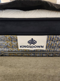 Close-up of a KingsDown Garland ET Plush Mattress label, showing micro gel tech and its patterned surface with bedding.