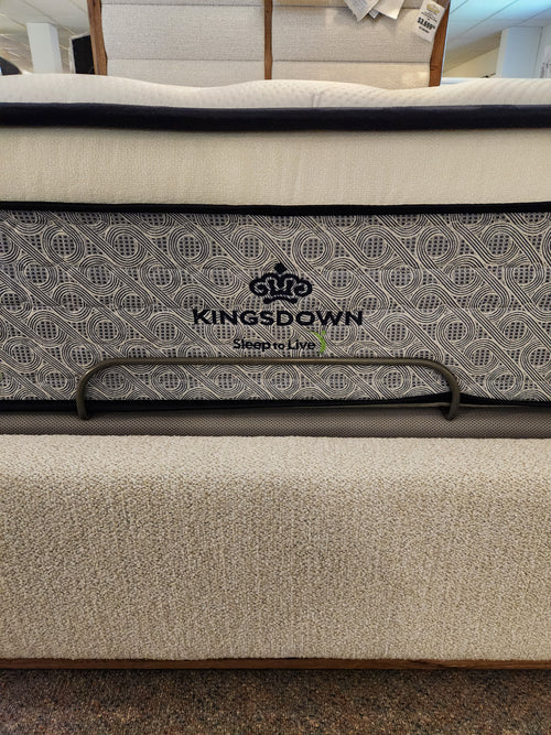 Close-up of a KingsDown Radiance 2 ET Plush Mattress with patterned fabric and metal handles in a showroom.