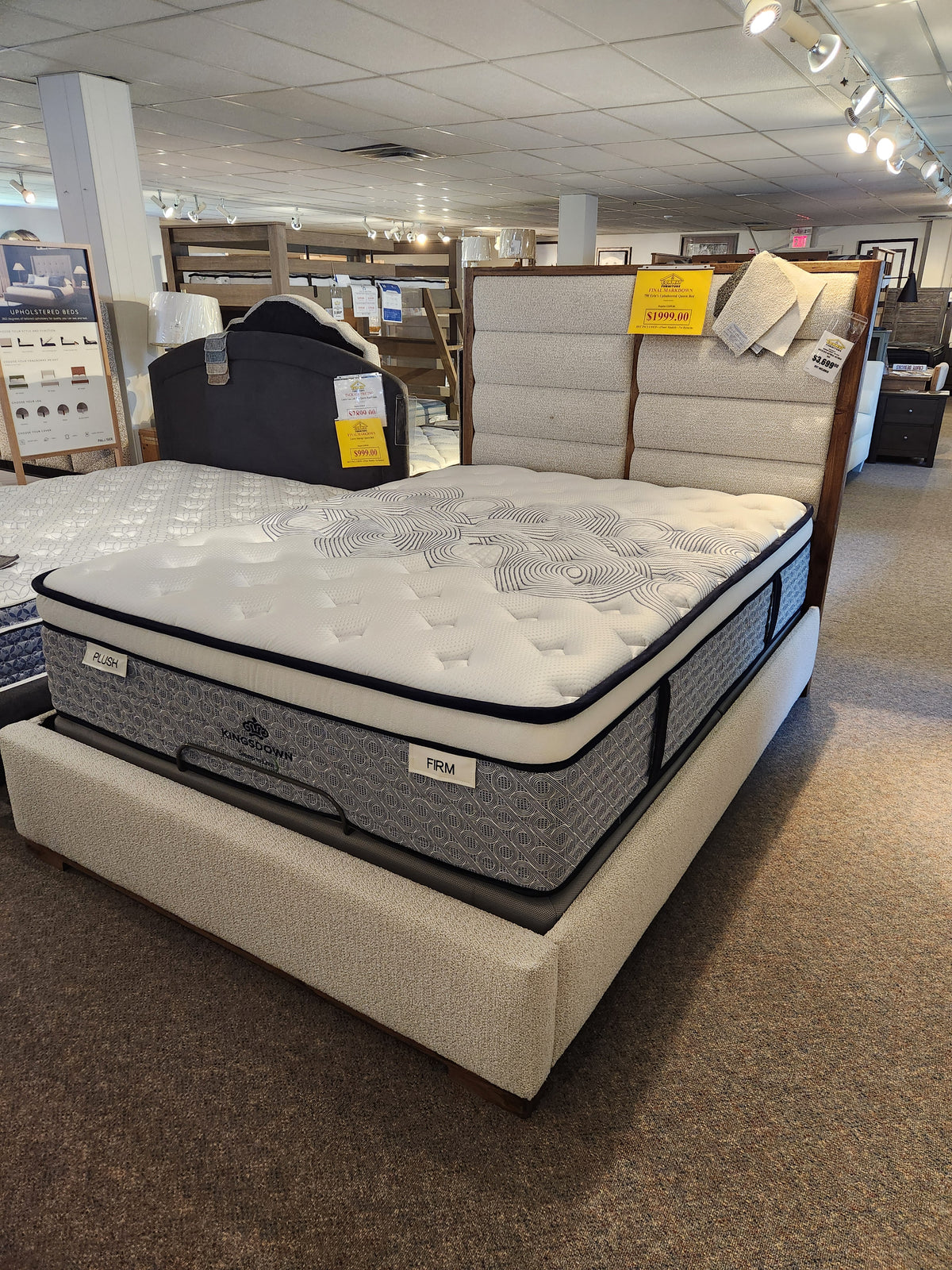 A KingsDown Radiance 2 ET Plush Mattress with patterned cover offers optimal support in a well-lit showroom.