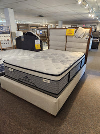 A KingsDown Radiance 2 ET Plush Mattress with patterned cover offers optimal support in a well-lit showroom.