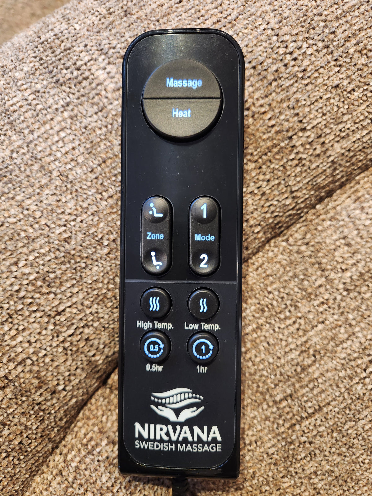 A Golden Noah UC-566 Med Power Lift Chair remote rests on brown fabric, showing massage and HeatWave settings.