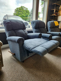 A La-z-boy 512 Pinnacle Rocker Recliner with contour cushion sits extended by two others near a large showroom window.