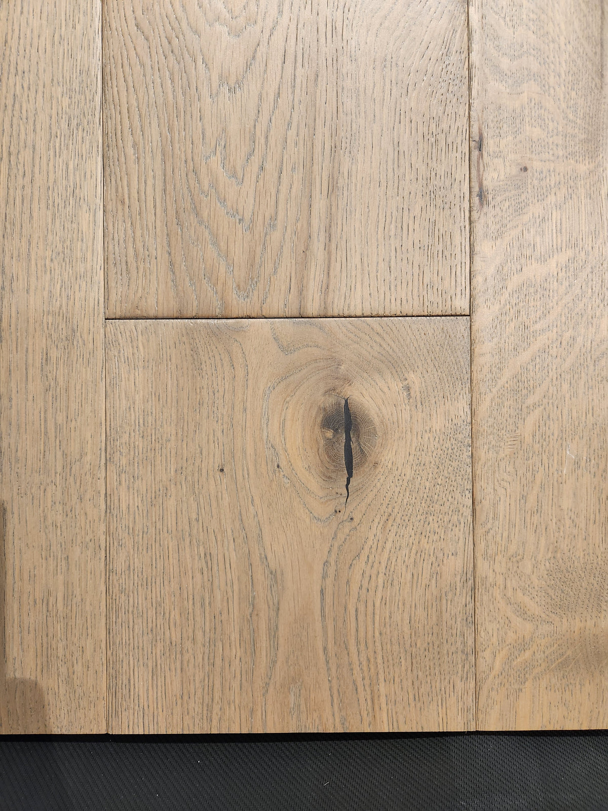 Close-up of Beckham Brothers' Montana Plank White Oak flooring, highlighting its grain patterns and central knothole.