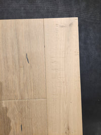 Close-up of Beckham Brothers Montana Plank White Oak flooring, planks arranged at right angles on a dark surface.