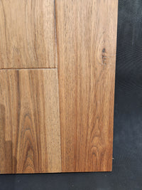 Close-up of Montana Plank White Oak by Beckham Brothers, showing grain patterns and seams on a dark textured background.