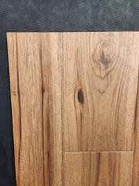 A close-up of Beckham Brothers Montana Plank White Oak flooring against a dark textured background.