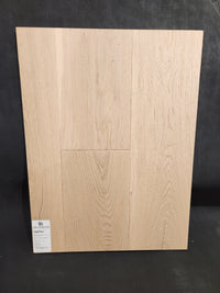 Beckham Brothers Montana Plank White Oak sample board with grain pattern, displayed upright on a dark background.