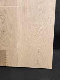 Close-up of Beckham Brothers Montana Plank White Oak flooring with visible grain, joined against a dark background.