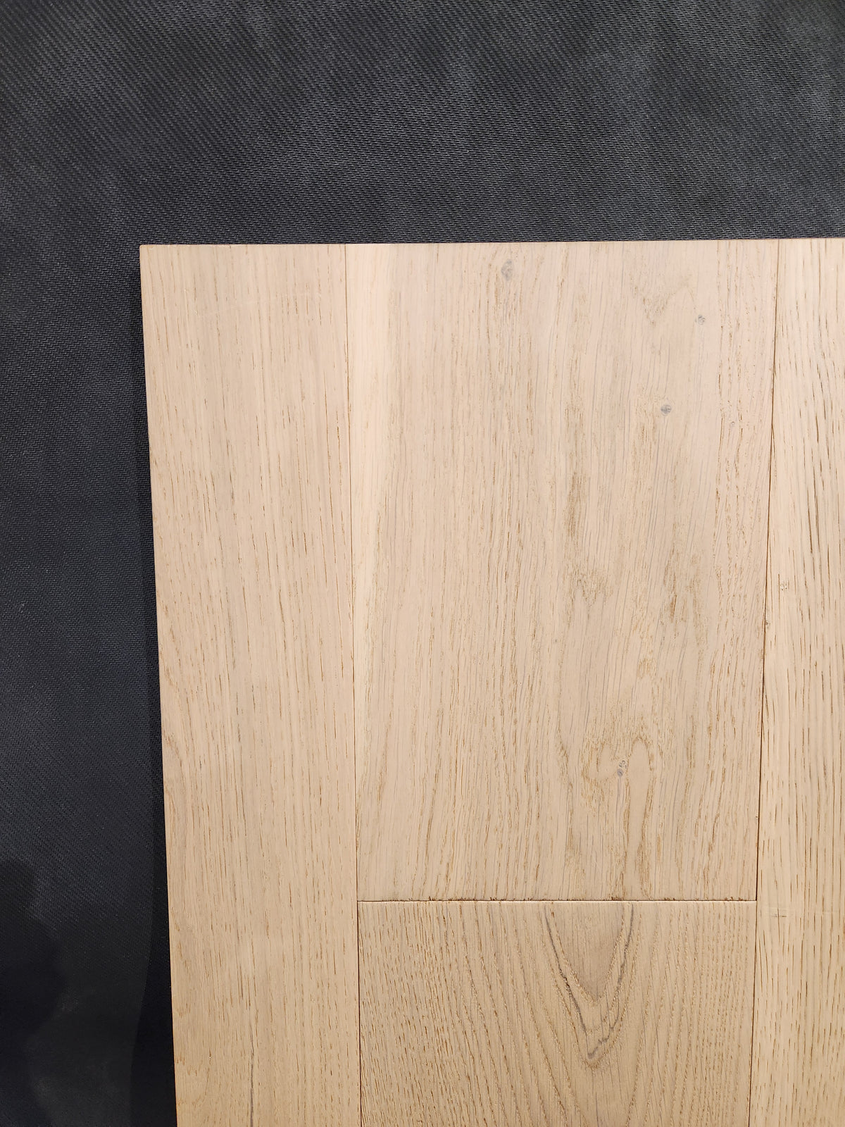 Montana Plank White Oak by Beckham Brothers displays its grain and pattern on a dark textured background.