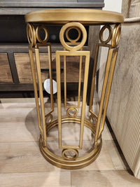 The Magnussen T6300 - Lorena Round Accent Table with brass finish sits by a beige sofa in a traditional room.