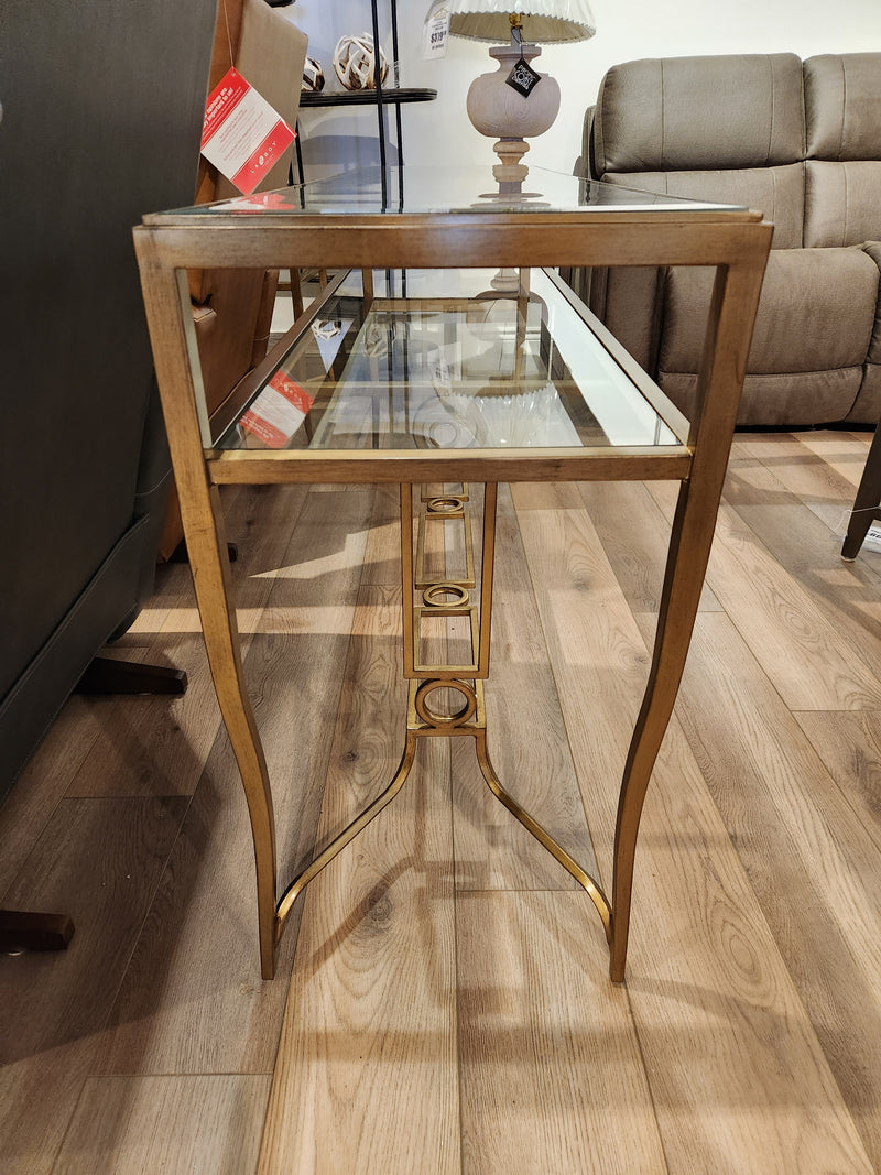 Magnussen T6300 - Lorena Sofa Table with burnished brass finish on display in a furniture showroom.