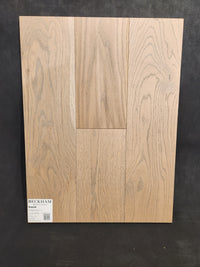 A sample board of Beckham Brothers Heritage Plank White Oak flooring shows visible grain patterns, labeled in the corner.