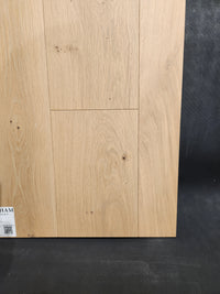 Beckham Brothers’ New York Loft White Oak-Hardwood: light wood panel with visible grain and knots.