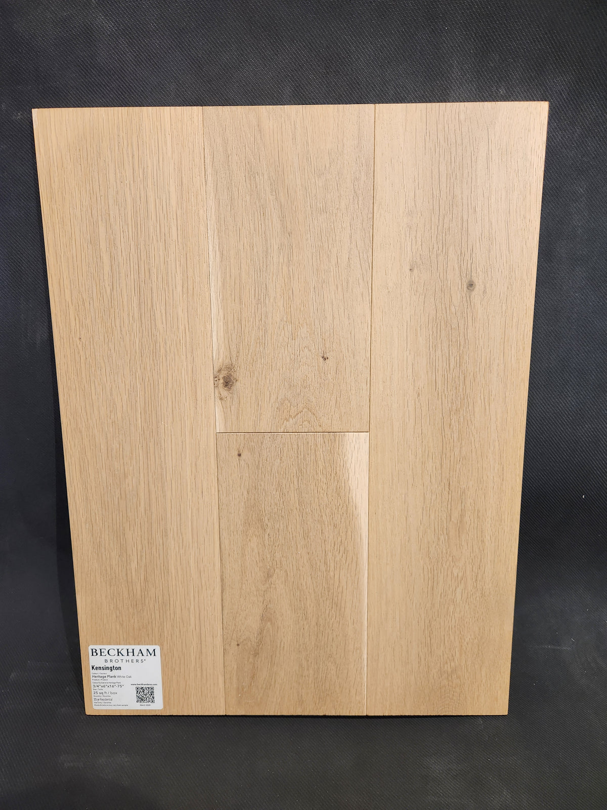 Light oak sample of Beckham Brothers Heritage Plank White Oak, three planks upright against a dark background.